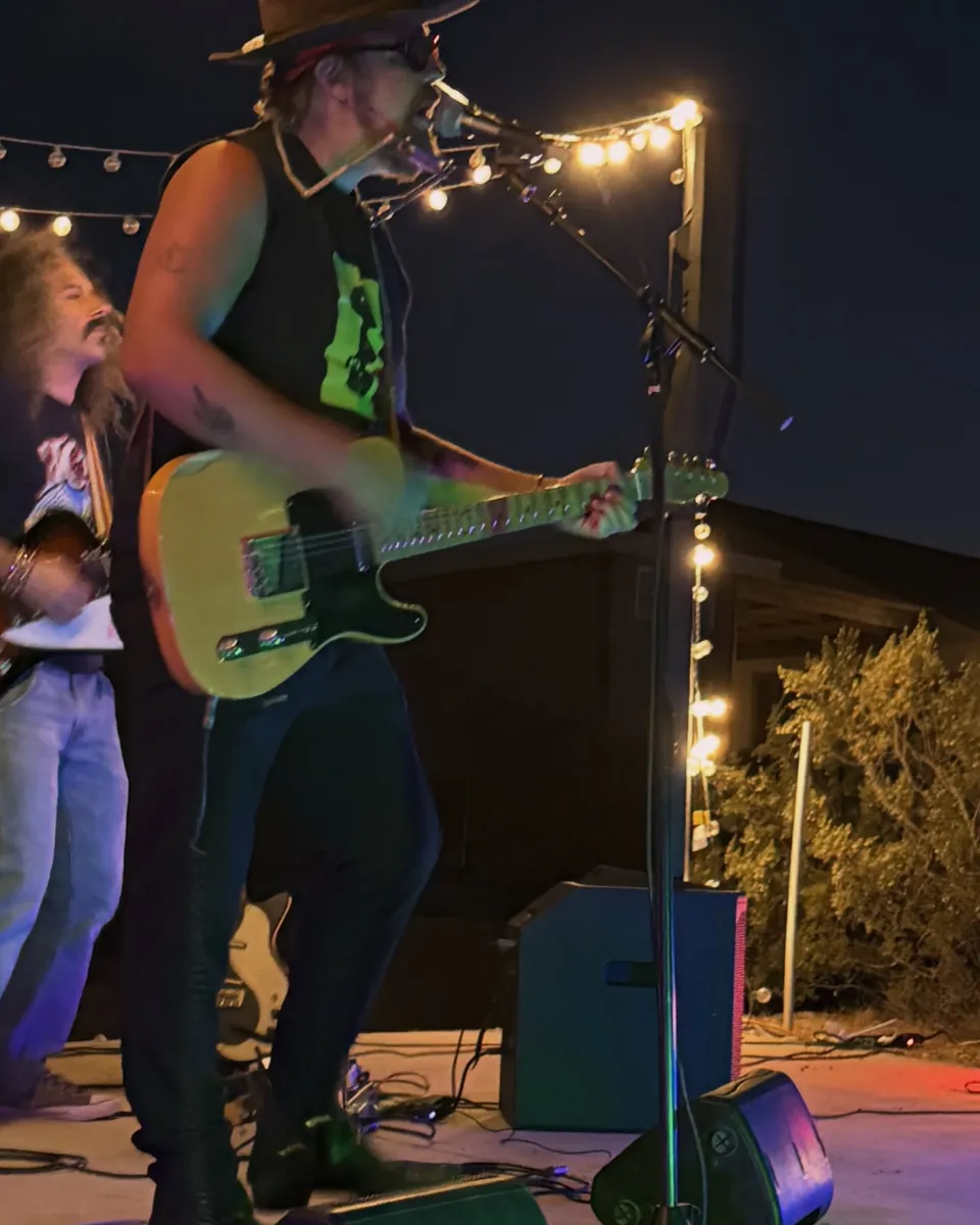 Brad Byrd playing guitar on the outdoor stage at night